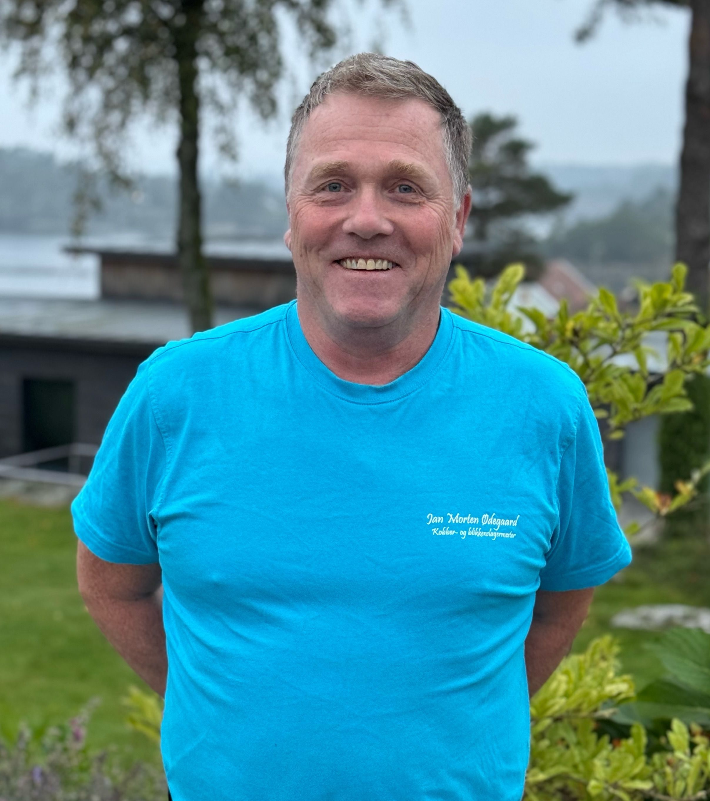 Smilende mann med blå t-skjorte