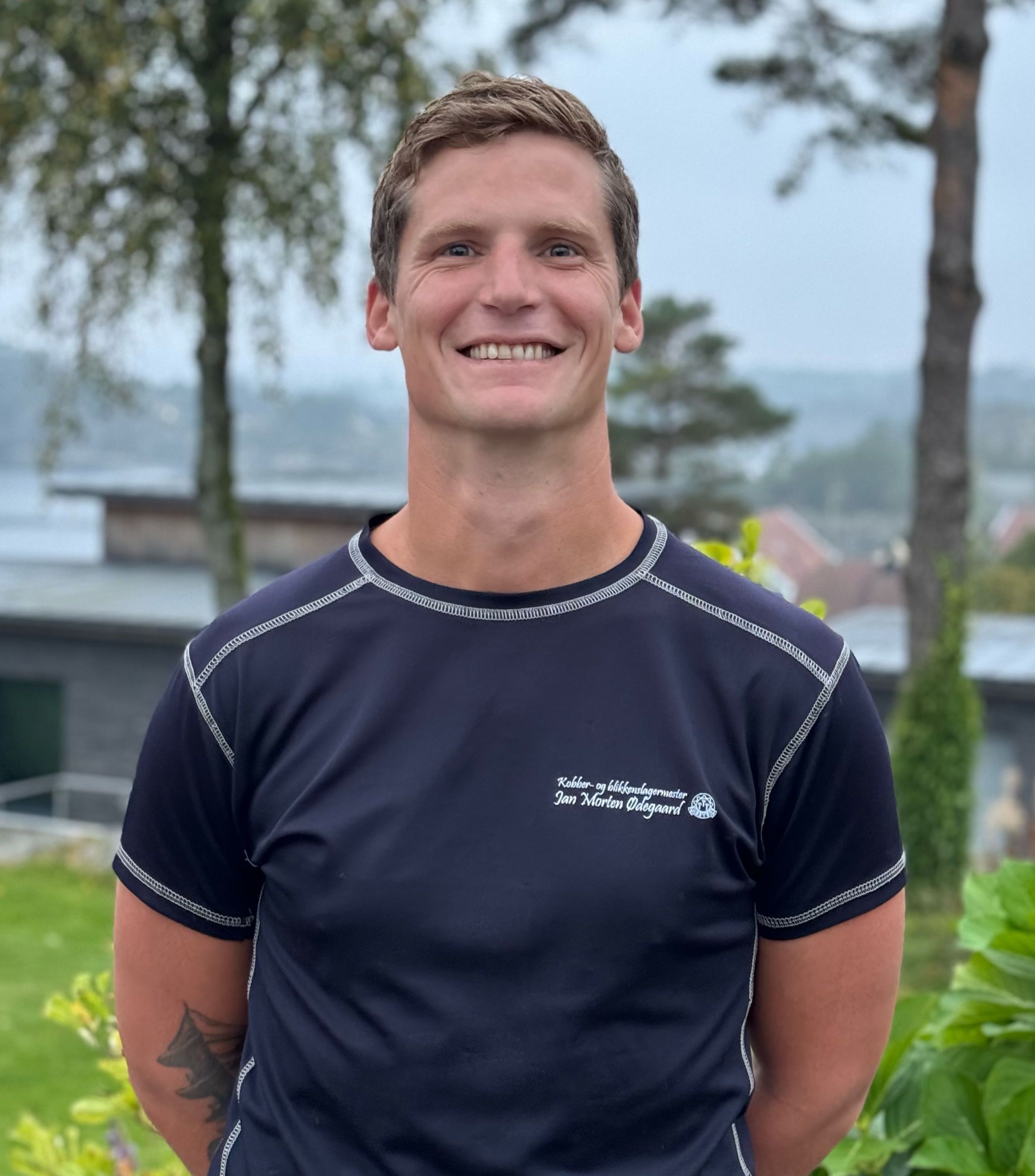 Smilende mann med mørkeblå t-skjorte