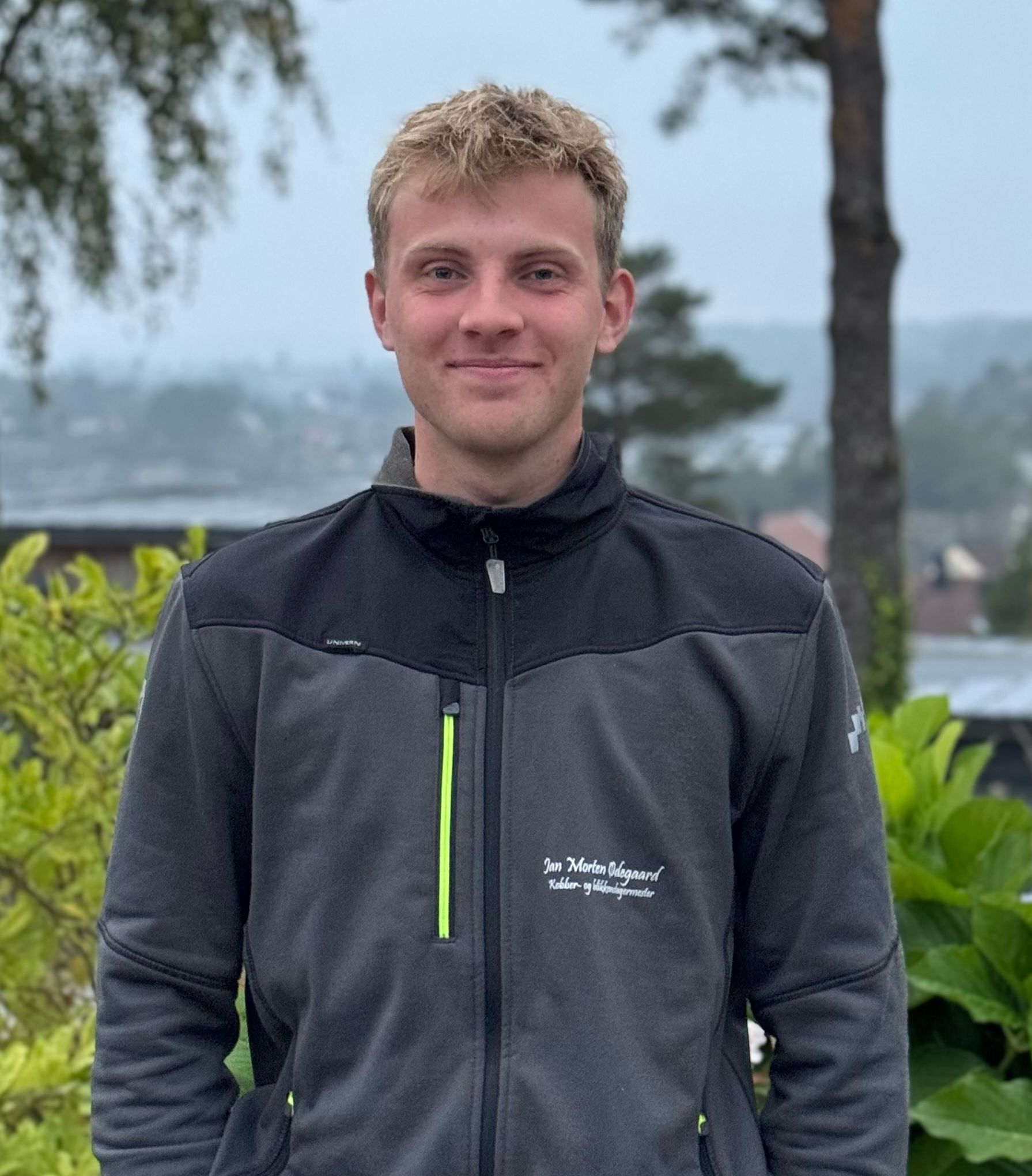 Smilende mann med grå jakke