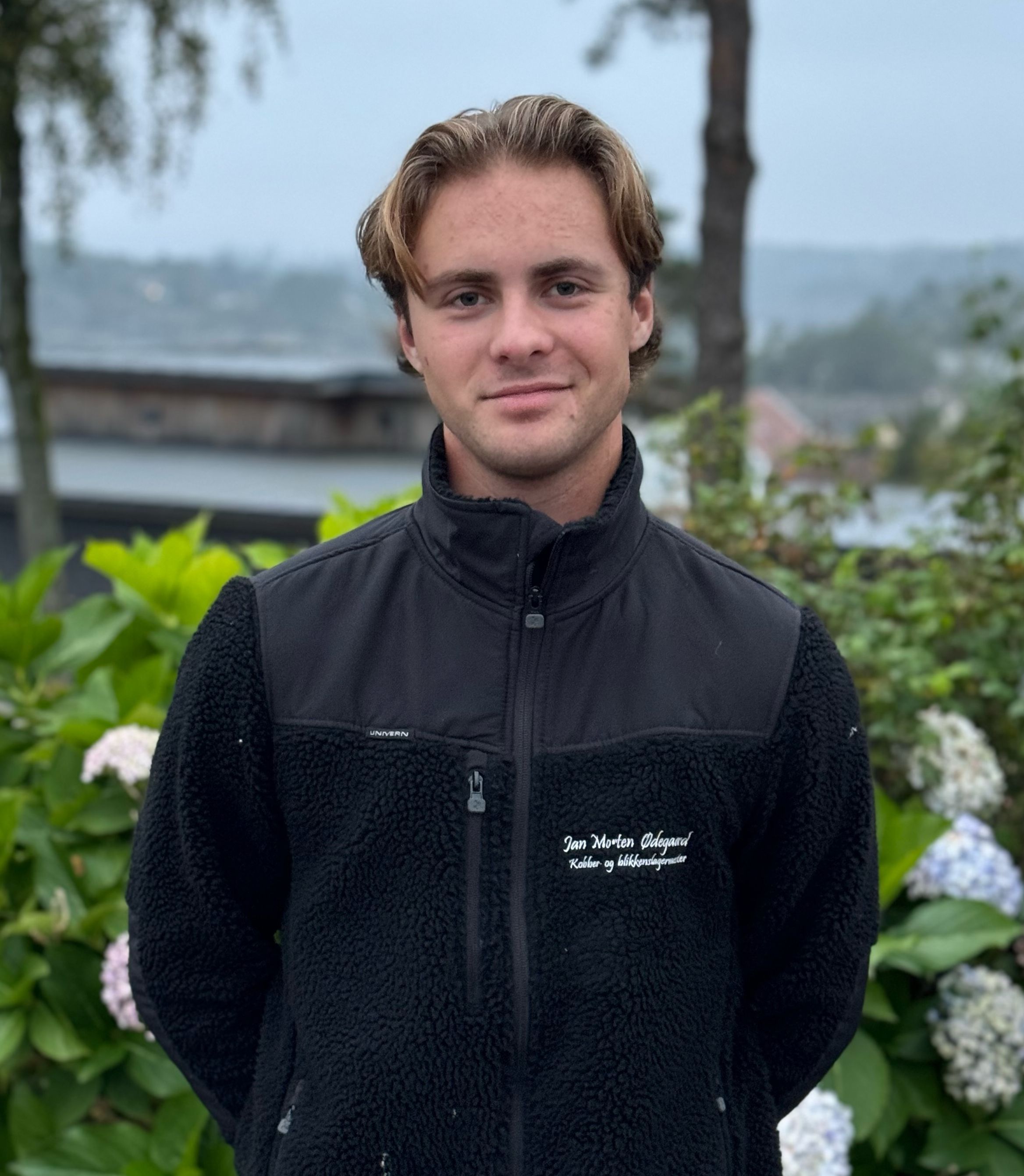 Smilende mann med svart jakke